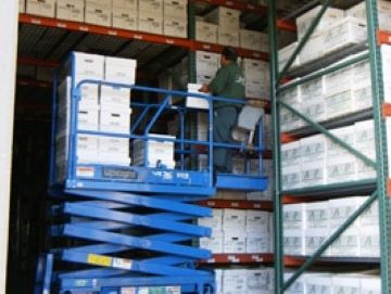 Cardboard Boxes being moved onto a shelf in a storage warehouse